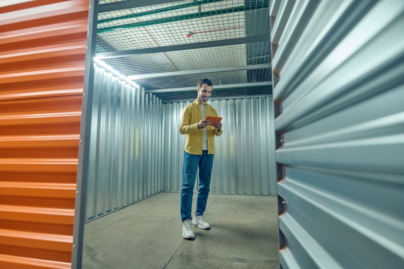 smiling-man-looking-tablet-empty-garage (1)