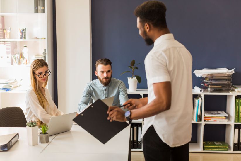 homem apresntando seu trabalho para pessoas